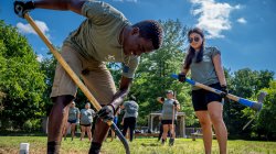 Two students take turns digging a hole