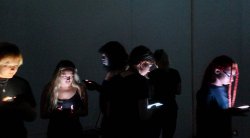 group of students walking in the dark holding cell phones
