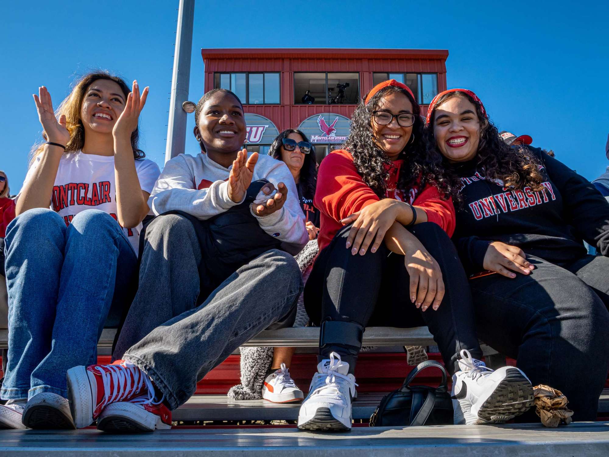 Game attendees clapping and smiling in the stands
