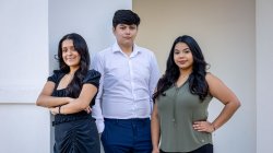 Three students in front of School of Nursing arches