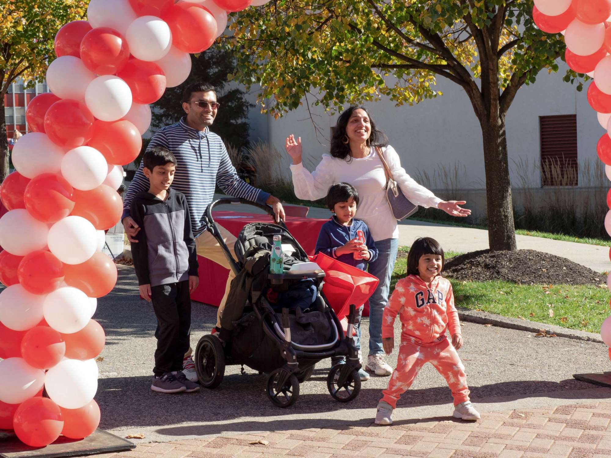Family smiling under balloon arch