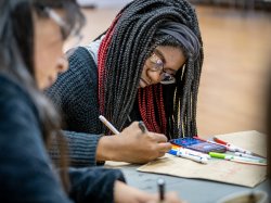 A female student draws on a bag.