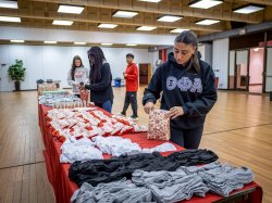 Four students fill care package bags.