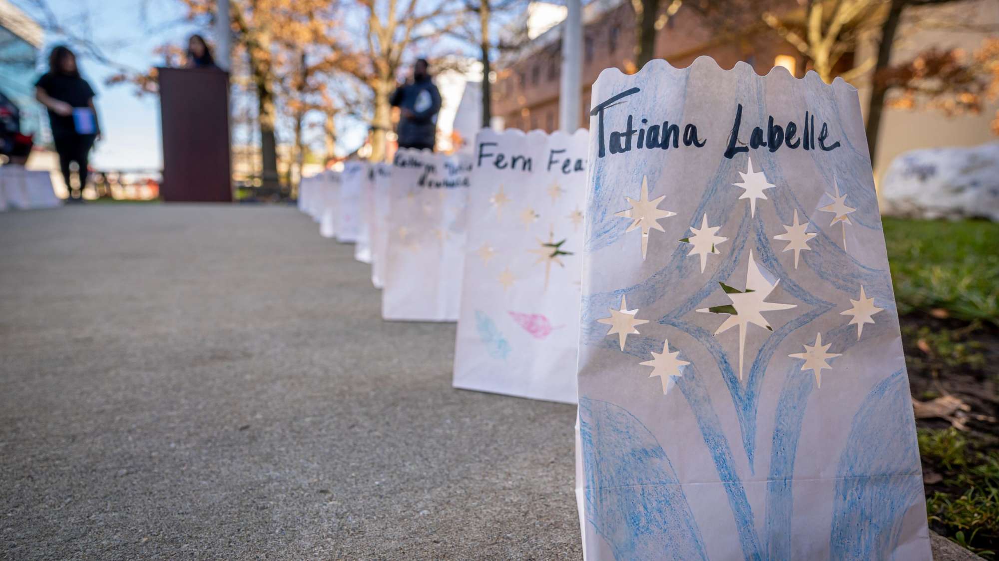 Luminaria line the walkway as part of a vigil for Trans Day of Remembrance.