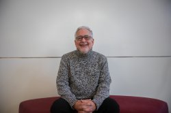 A man sits and smiles.