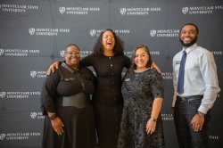 A woman laughs, as she’s flanked by three other people.