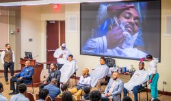 Students get haircuts during a panel discussion.