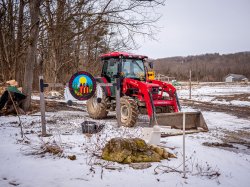 A tractor in a snow-covered field.