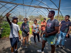 A guide leads students on a tour through a garden.