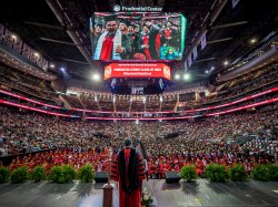 President Koppell speaks on stage at Commencement in front of graduates, families and friends