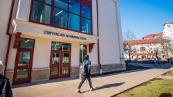 Student walking past the entrance of the Center for Computing and Information Science