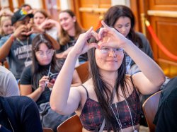 Students make a heart shape with their hands.