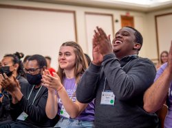 Students smile and applaud.