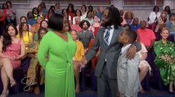 Man, woman and young child standing in front of an audience