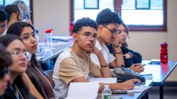 Students sit in a classroom listening to a speaker.