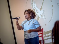 A student sings into a microphone.