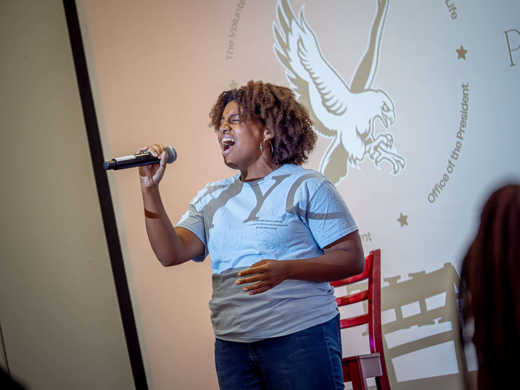 A student sings into a microphone.