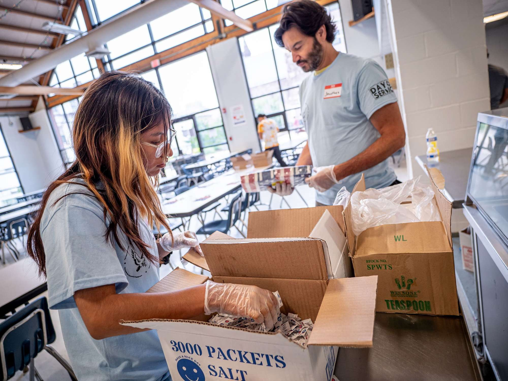 A student and the college president unpack boxes.