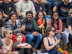 People in the crowd smile at the camera.