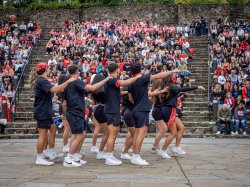 Dancers perform in front of a crowd in an outdoor amphitheater.