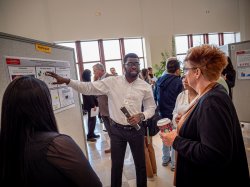 A student scientists explains his poster.