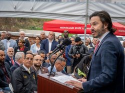 Jonathan Koppell speaks to the crowd inside a tent.