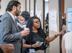 Montclair President Jonathan Koppell listens to a student as she explains her research.