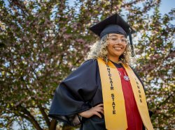 Student Mariana Luna-Martinez in graduation cap and gown with a gold honors stole.
