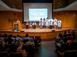 Faith Mogila administers an oath to audiology doctoral students before ceremony attendees.