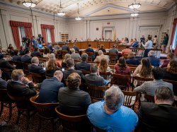A packed hearing room.