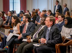 A group listens to a budget hearing.