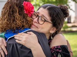 A woman and her daughter embrace.