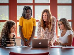Students and instructor looking at a laptop
