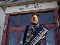 Bob Bailey-Lemanskyholds a keyboard outside the Cali School of Music.