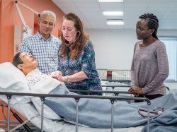 School of Nursing faculty and MSN students demonstrating functions of an intelligent simulator.