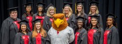 Nursing students posing with Rocky the Red Hawk at the School of Nursing Convocation.