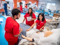 Nursing students preparing manikin for examination.