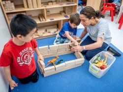 Teacher working with two children in children's center.