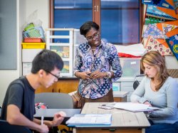 Photo of woman teaching students in classroom.