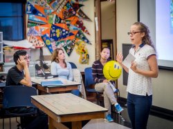Photo of a woman speaking in front of a classroom.