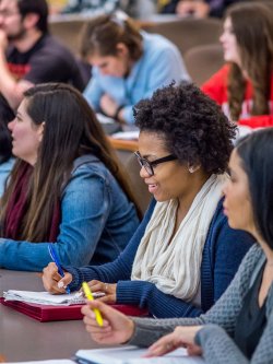 photo of students in class smiling and taking notes