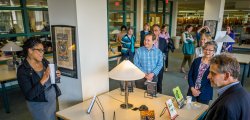 Group of faculty at University Authors event gathered around a table displaying faculty-written books.