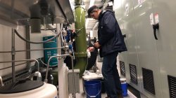 Green Team alum collecting water sample from pipe