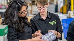 Green Team students looking at product