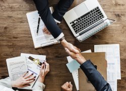 Picture of two people shaking hands across a desk