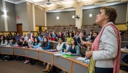 professor in lecture hall with many students seated