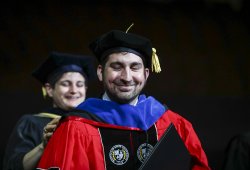 photo of Doctoral student Hogan being hooded at Commencement Ceremony
