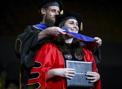 photo of PhD student Lauren Grove being hooded at Commencement ceremony