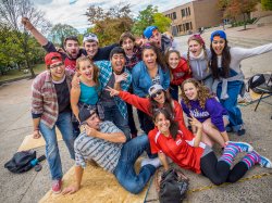 Image of a group of students standing outside the student center in fall.