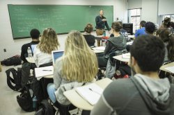 Photo of a classroom scene with Mark Clatterbuck teaching in front of a chalkboard.